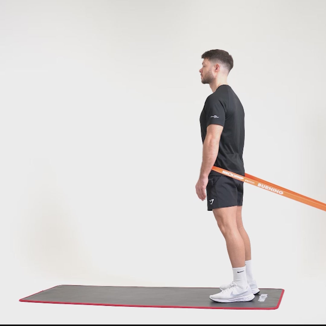 Eine Person trainiert auf einer Fitnessmatte mit einem langen Fitnessband aus Stoff und einer Curl-Bar